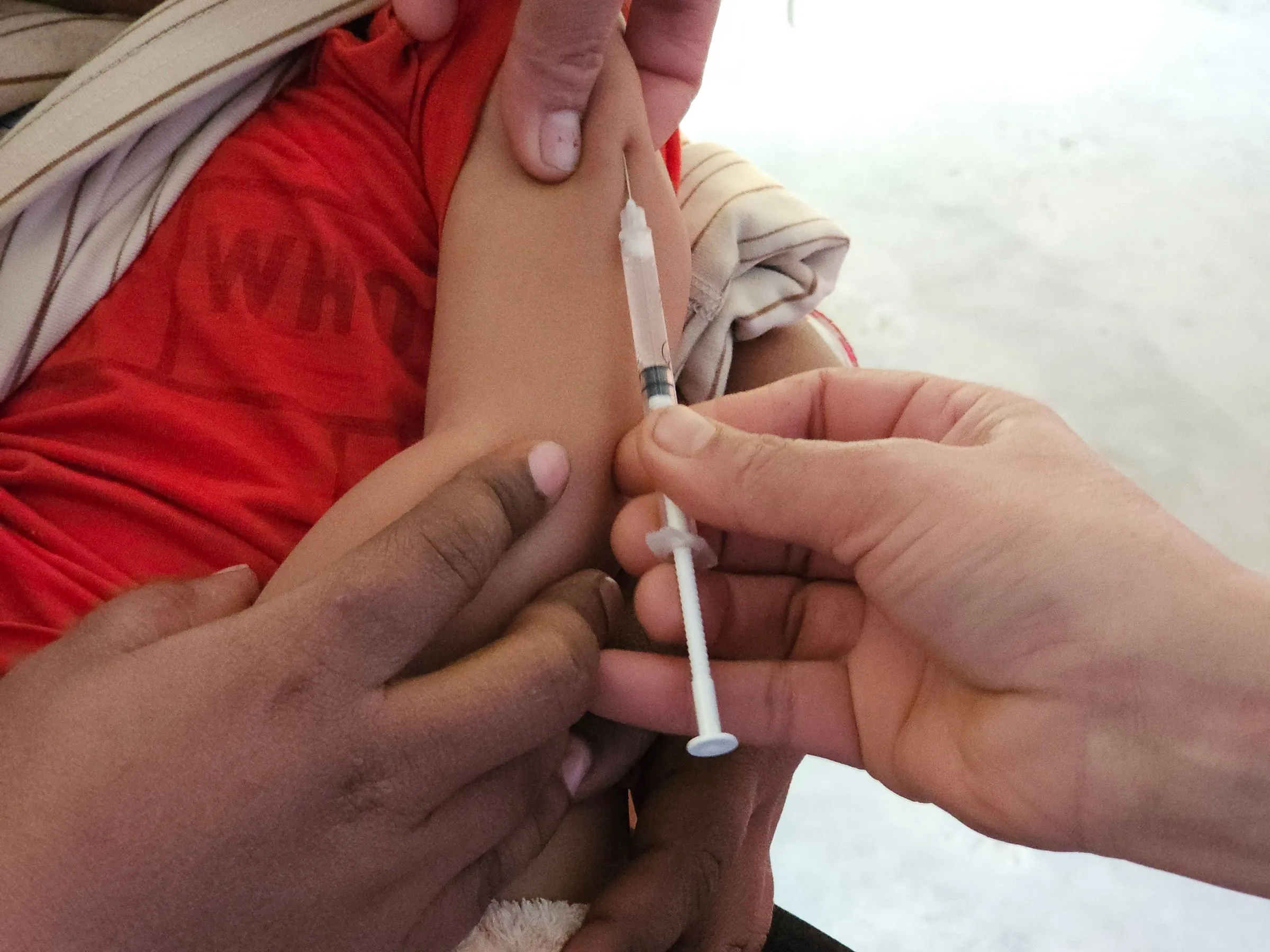 A child receiving an injection from a healthcare worker