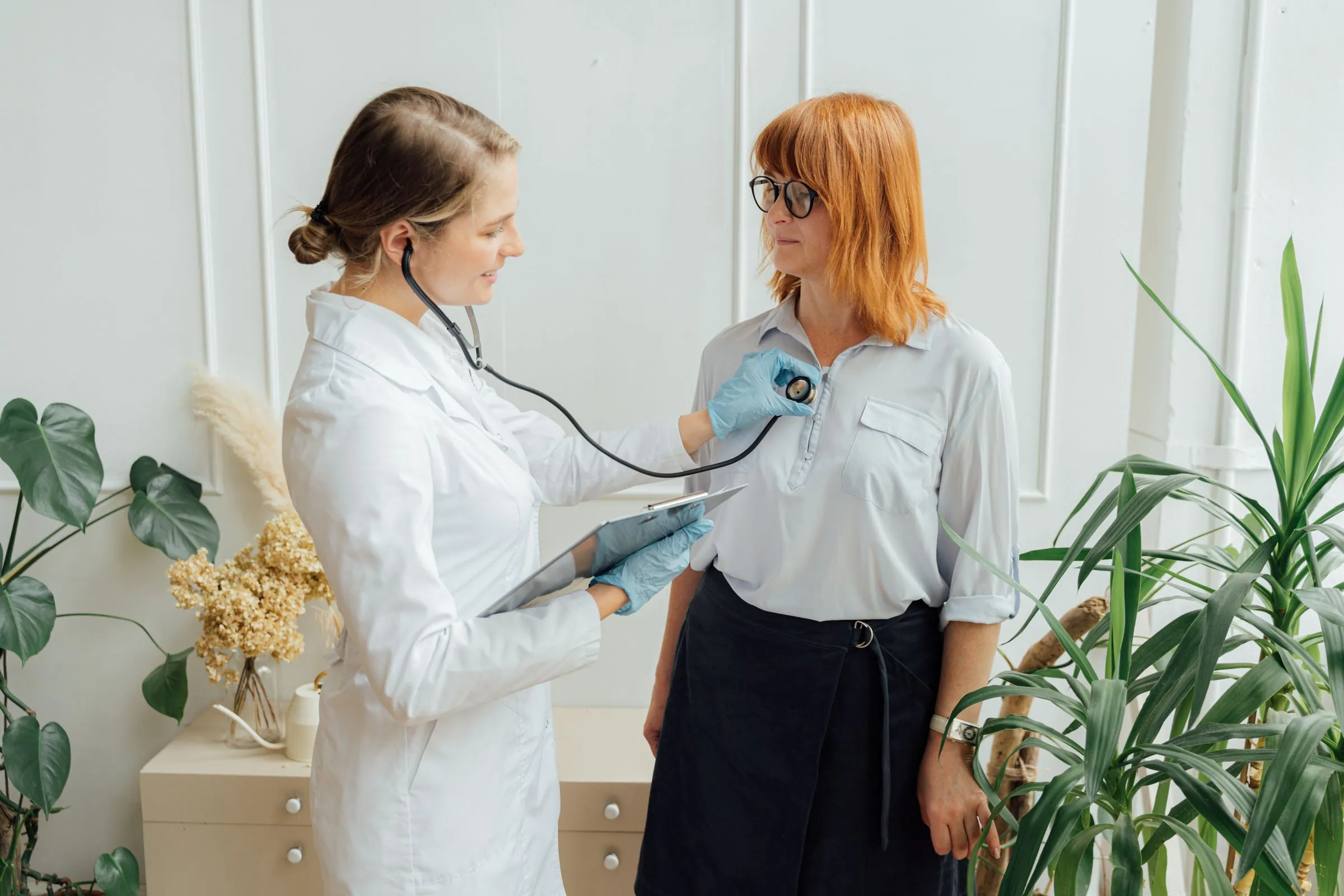 A doctor listening to a patient's chest with a stethoscope