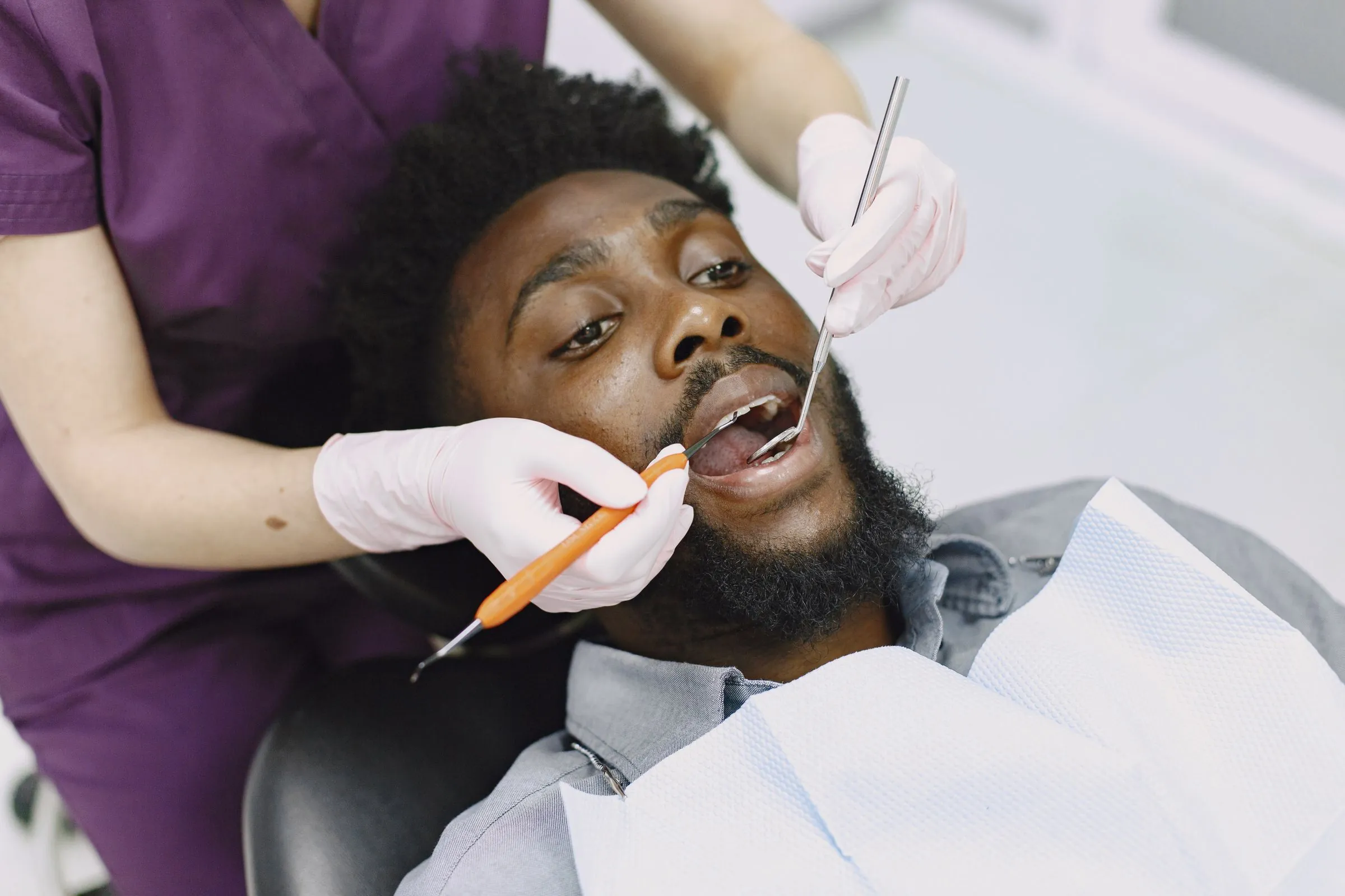 A dentist checking a patient's teeth during a routine appointment