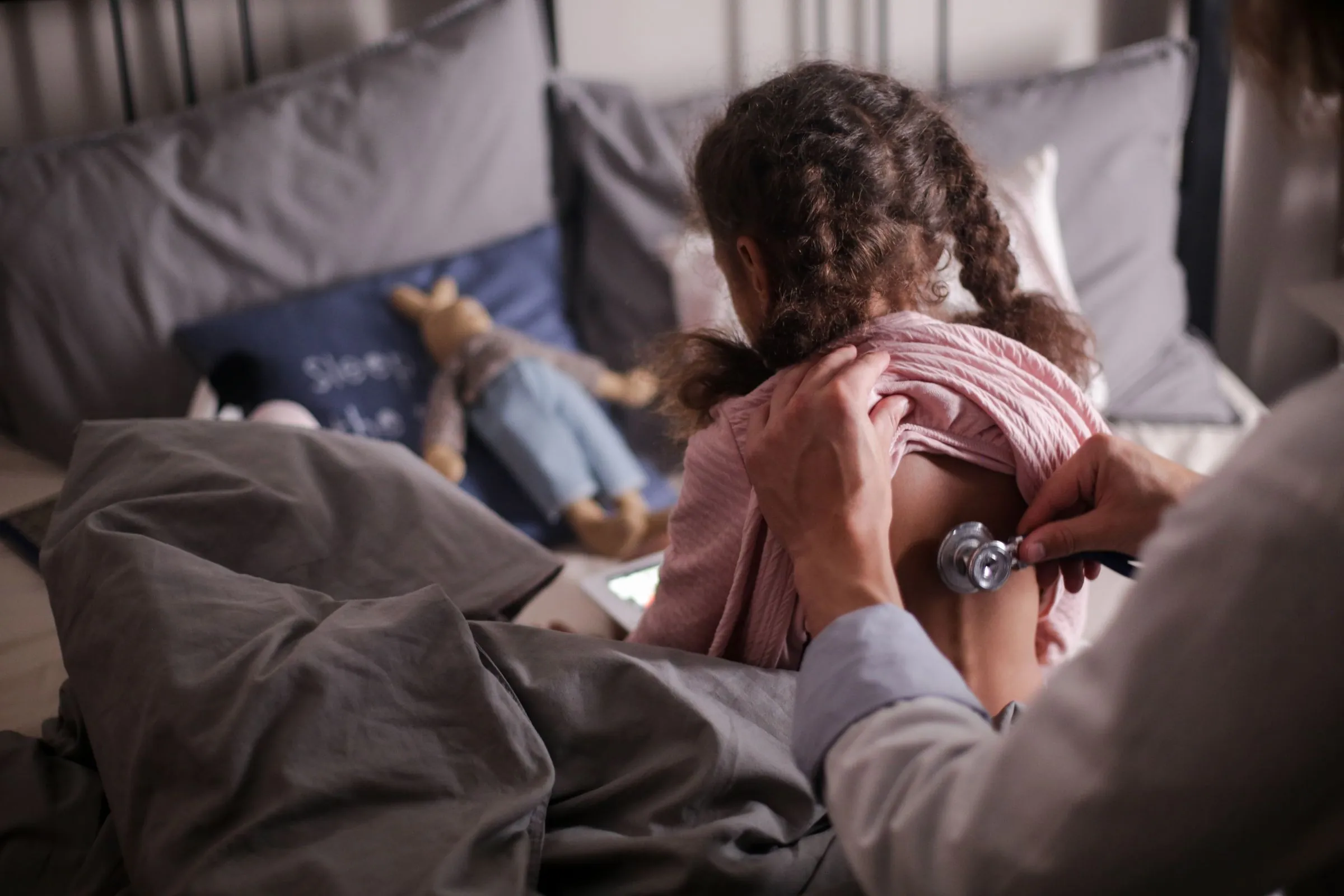 A paediatrician listening to a child's chest with a stethoscope