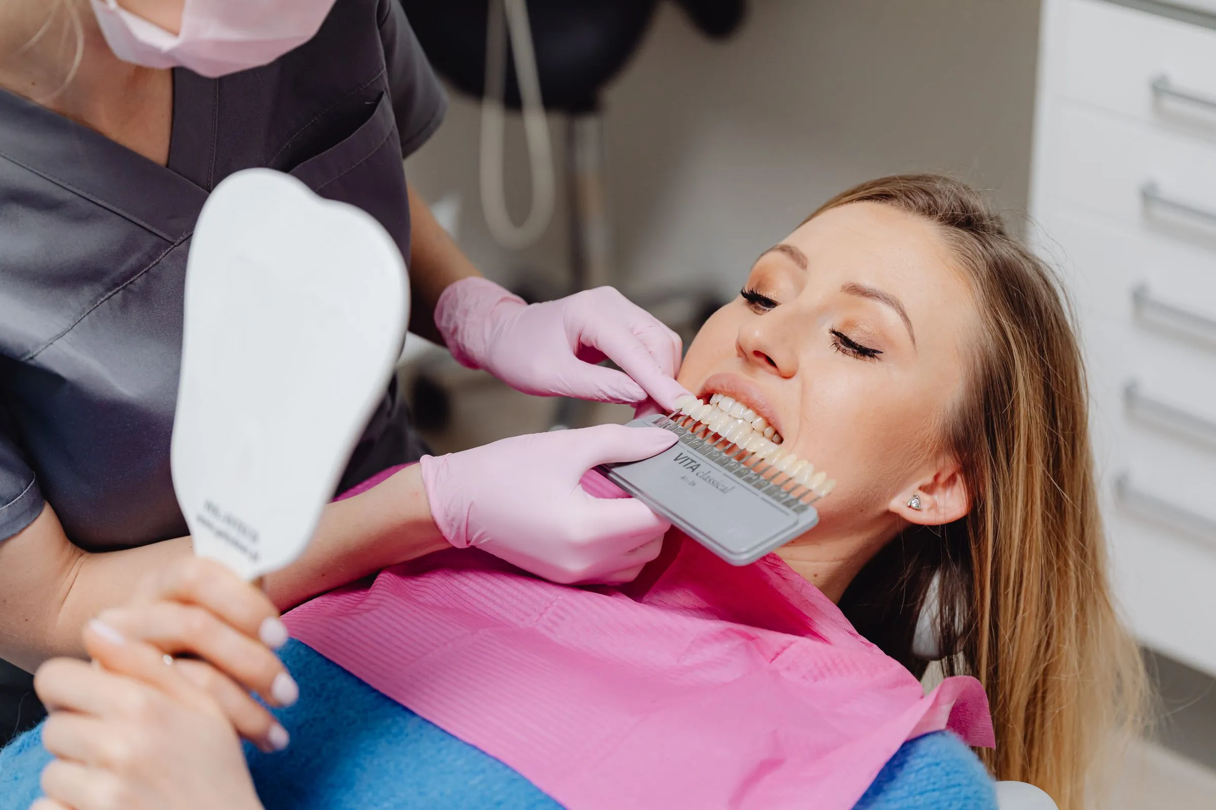 A dentist matching tooth colour with a shade guide
