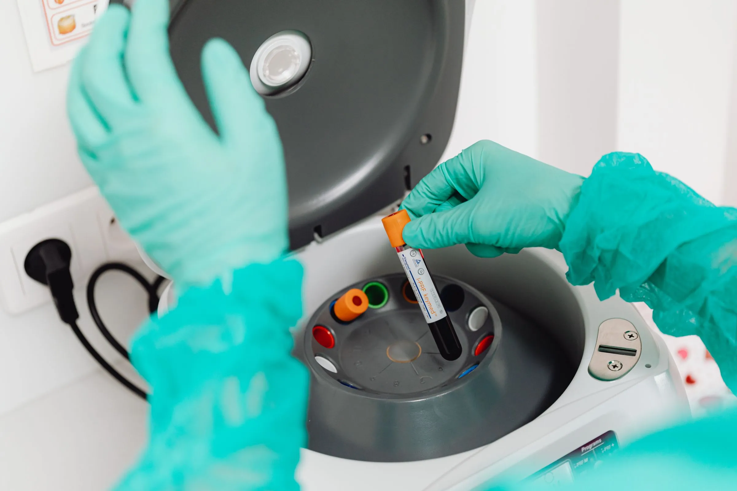 A laboratory technician loading blood samples into a centrifuge