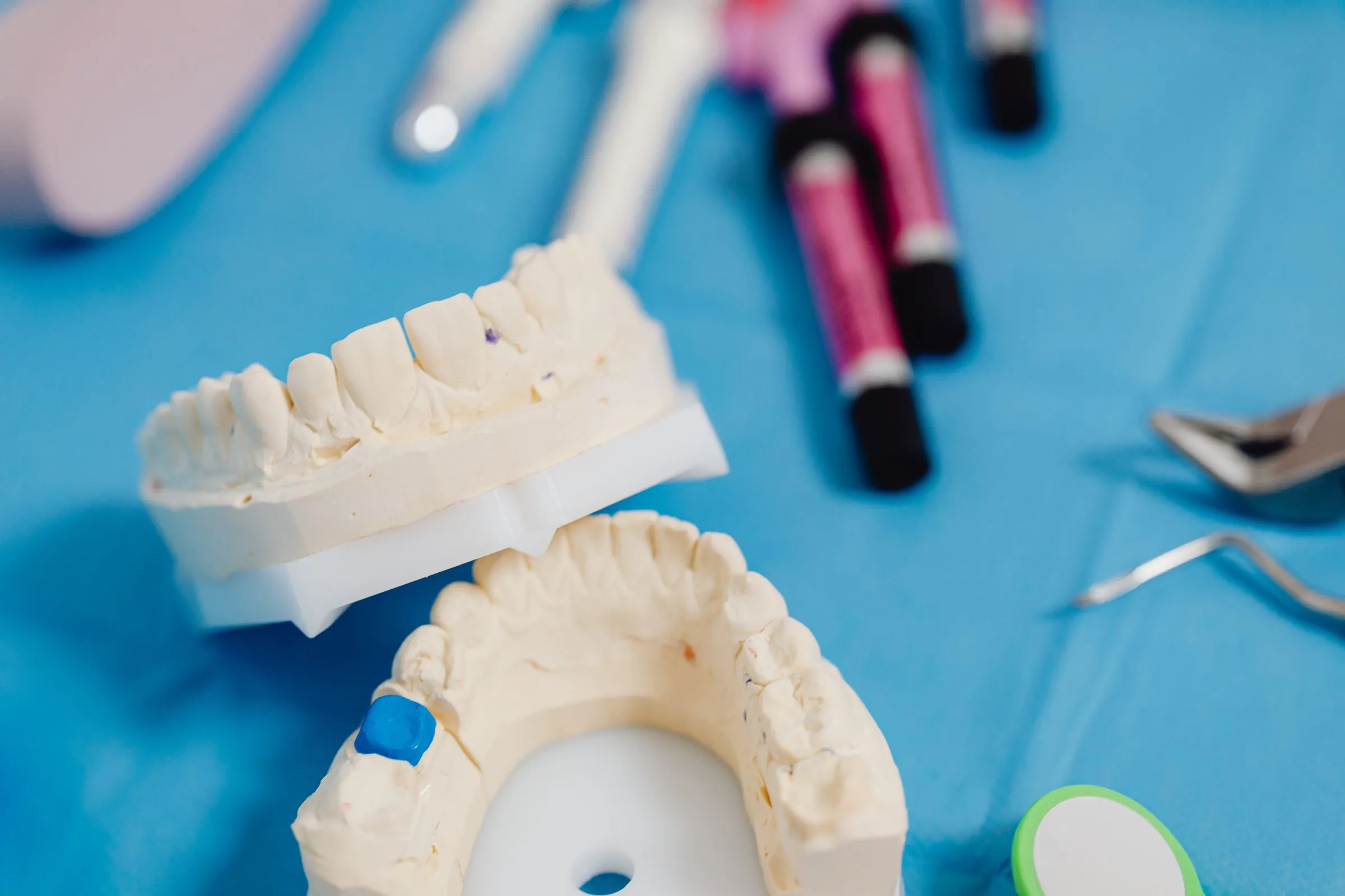 Composite resin syringes and dental casts laid out for treatment