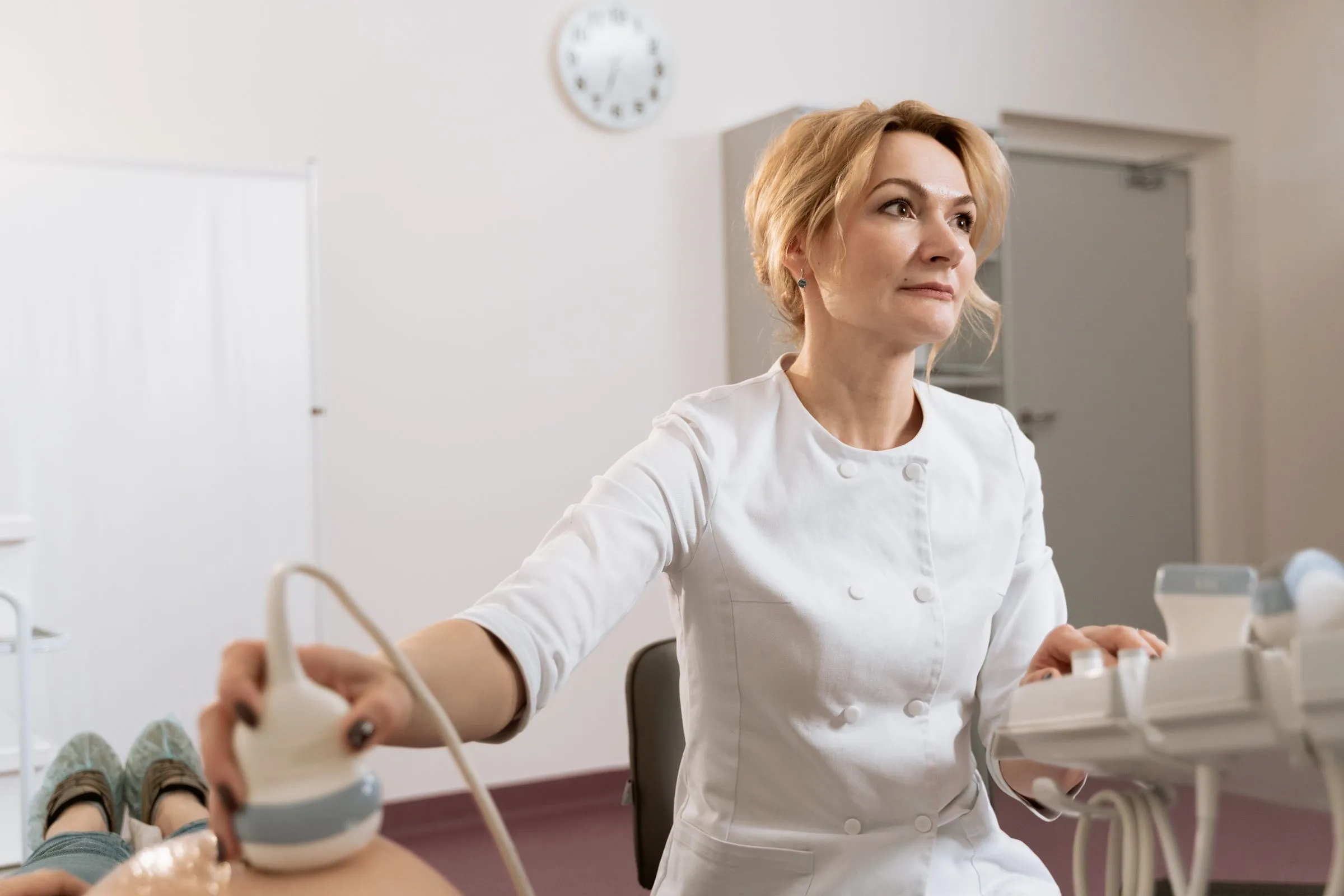 A clinician holding an ultrasound probe during a scan