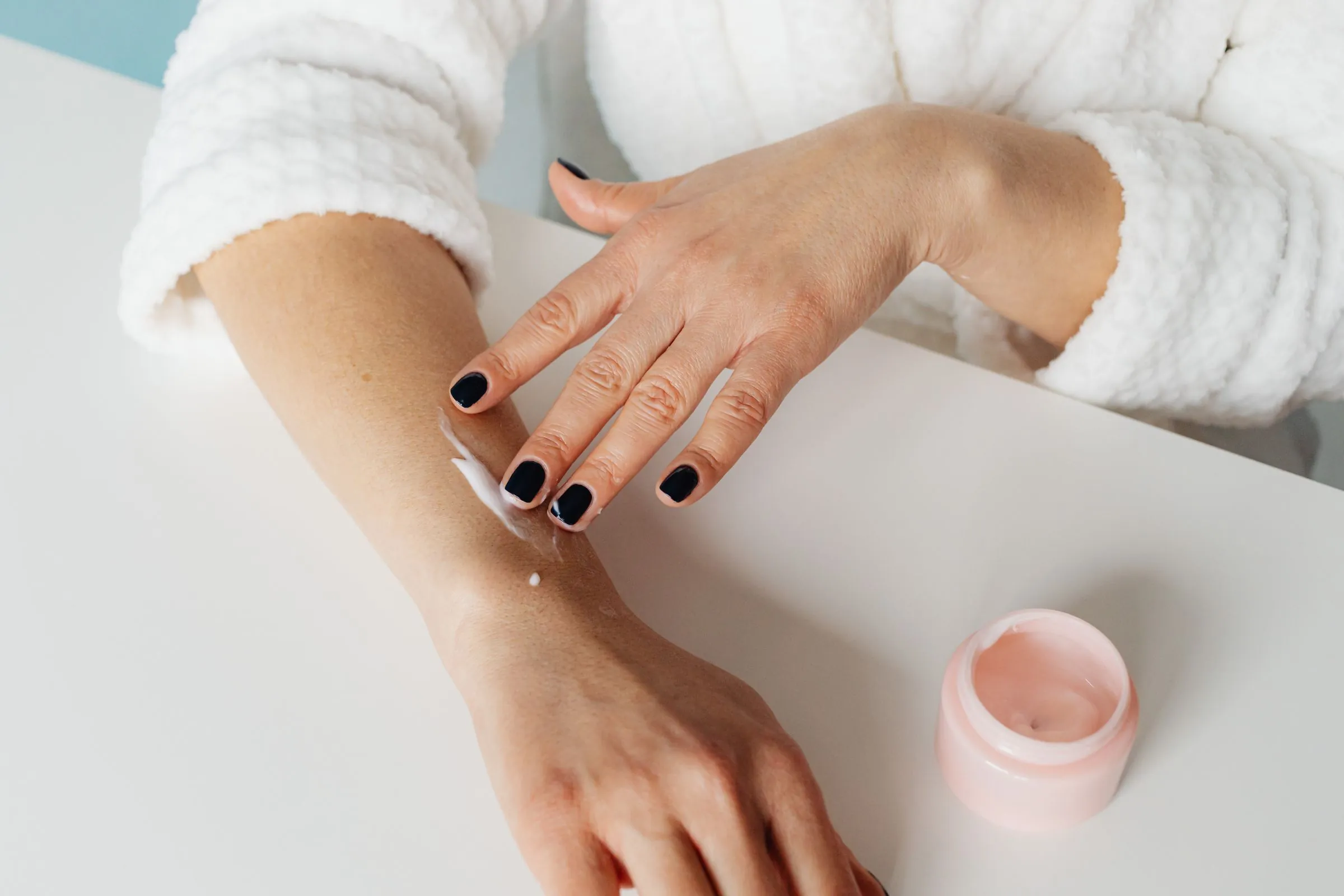 A moisturising cream being smoothed onto a forearm