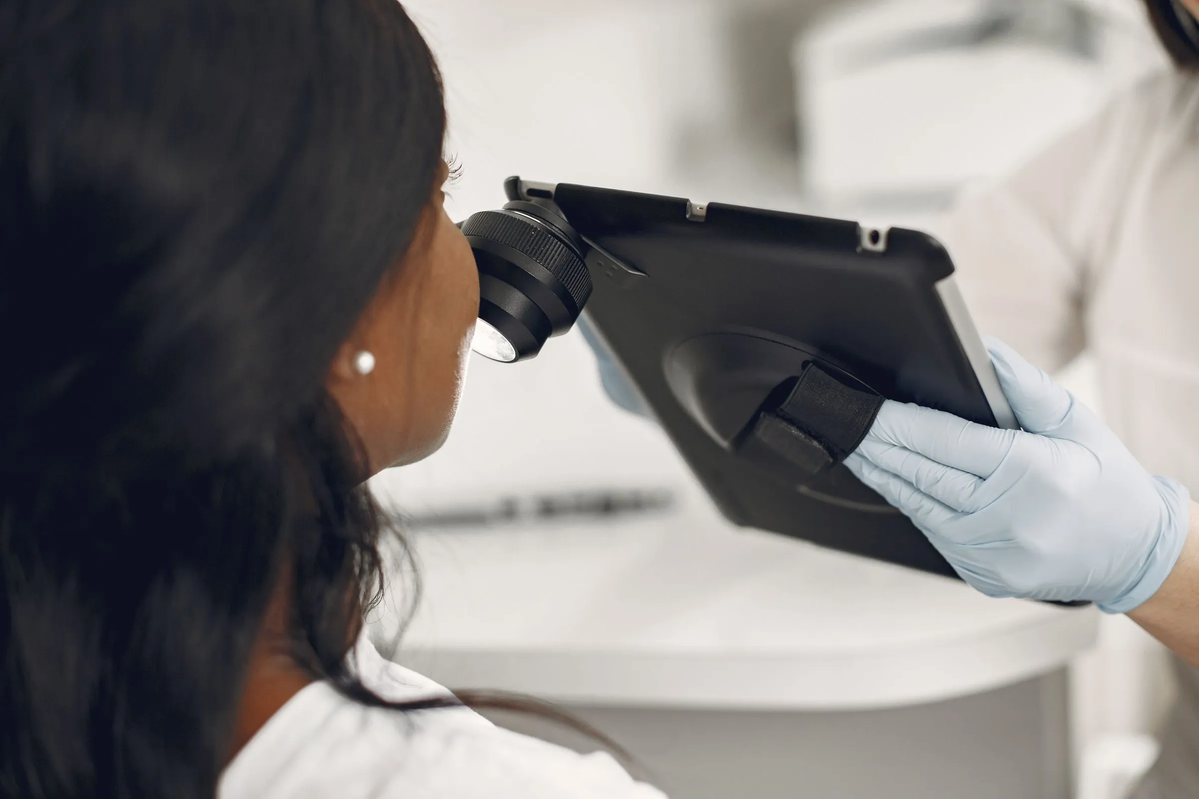 A dermatologist studying magnified skin images on a clinic screen