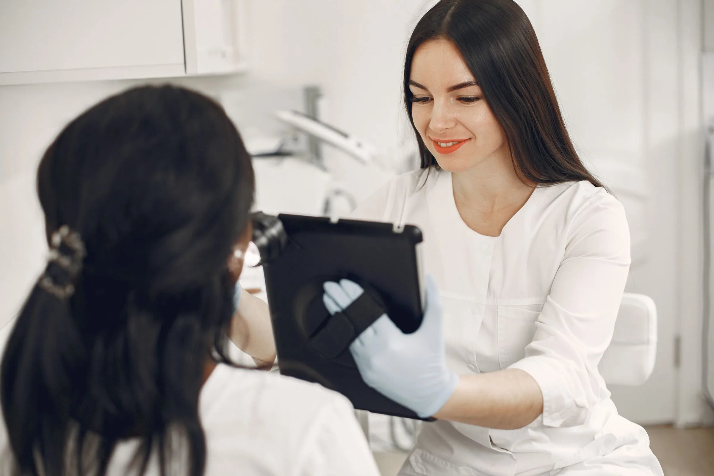 A clinician going through skin images on a tablet with a patient