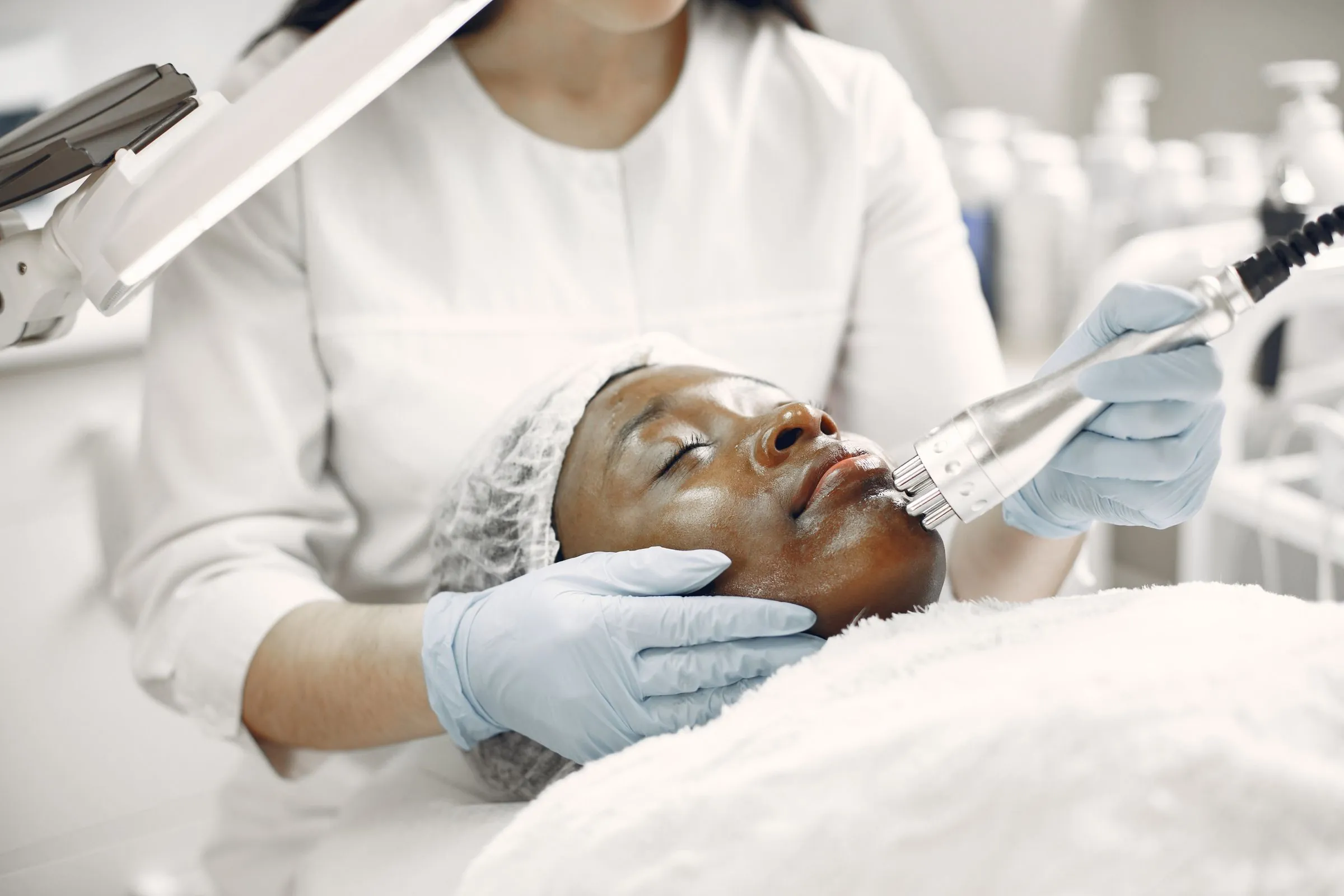 A dermatologist carrying out a light-based skin treatment in a clinic