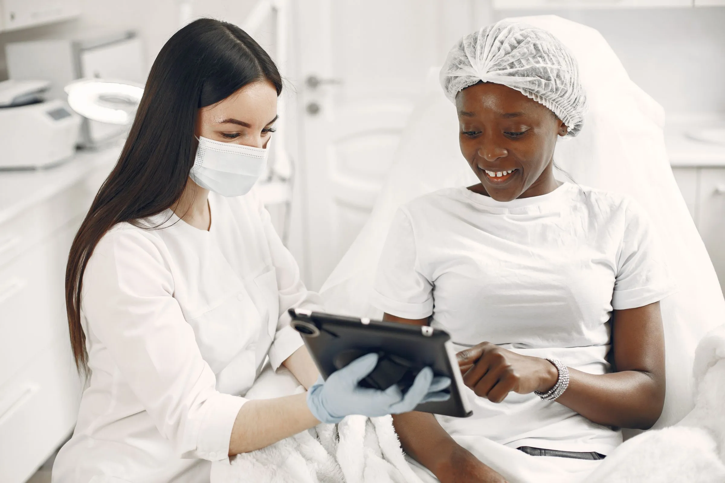 A dermatologist and a patient reviewing images together on a tablet