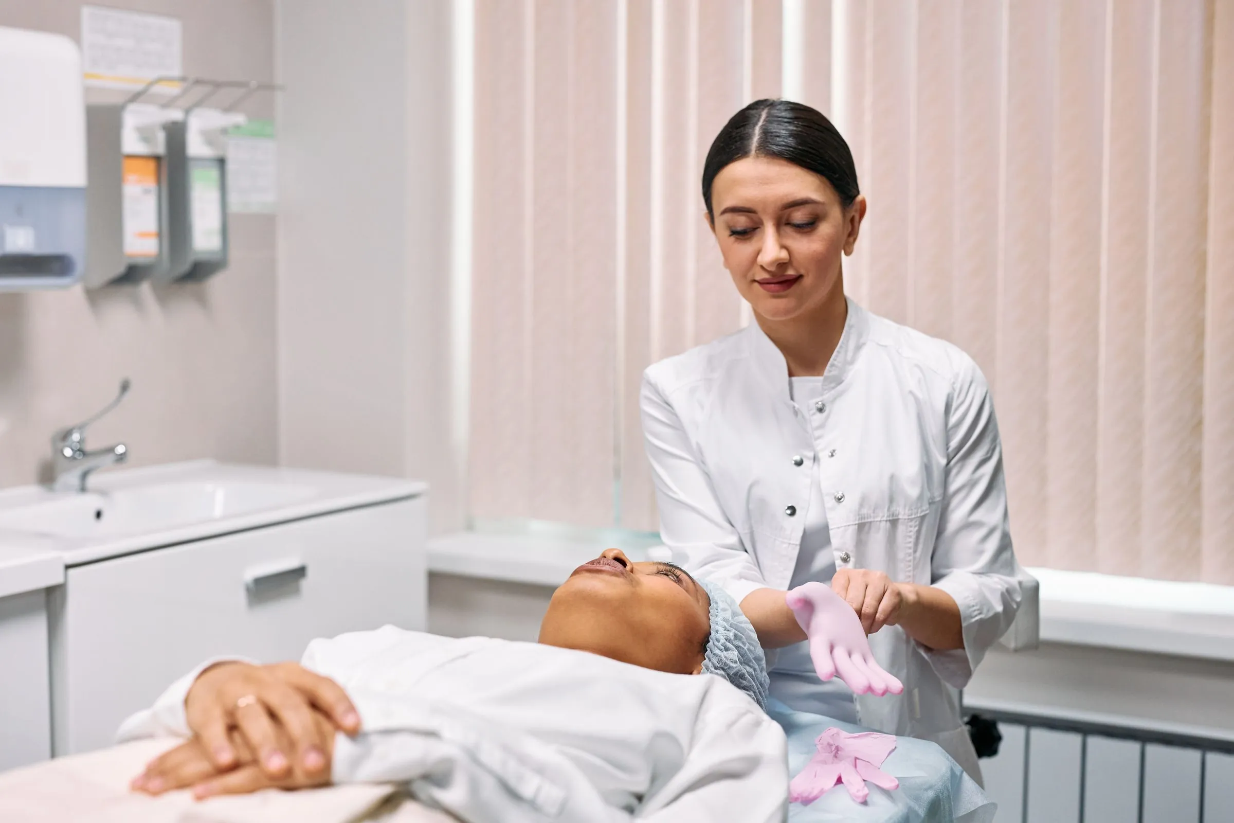 A clinician putting on gloves before a minor skin procedure