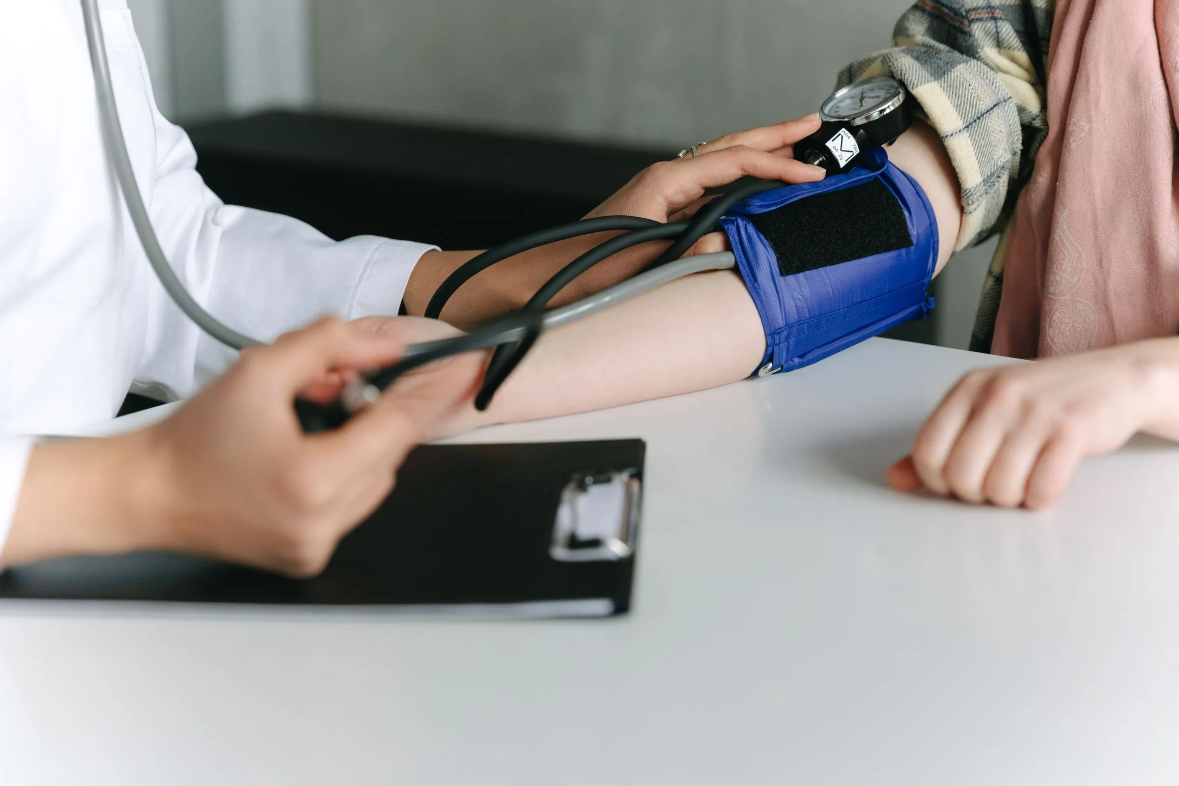 A blood pressure cuff and stethoscope being used on a patient's arm