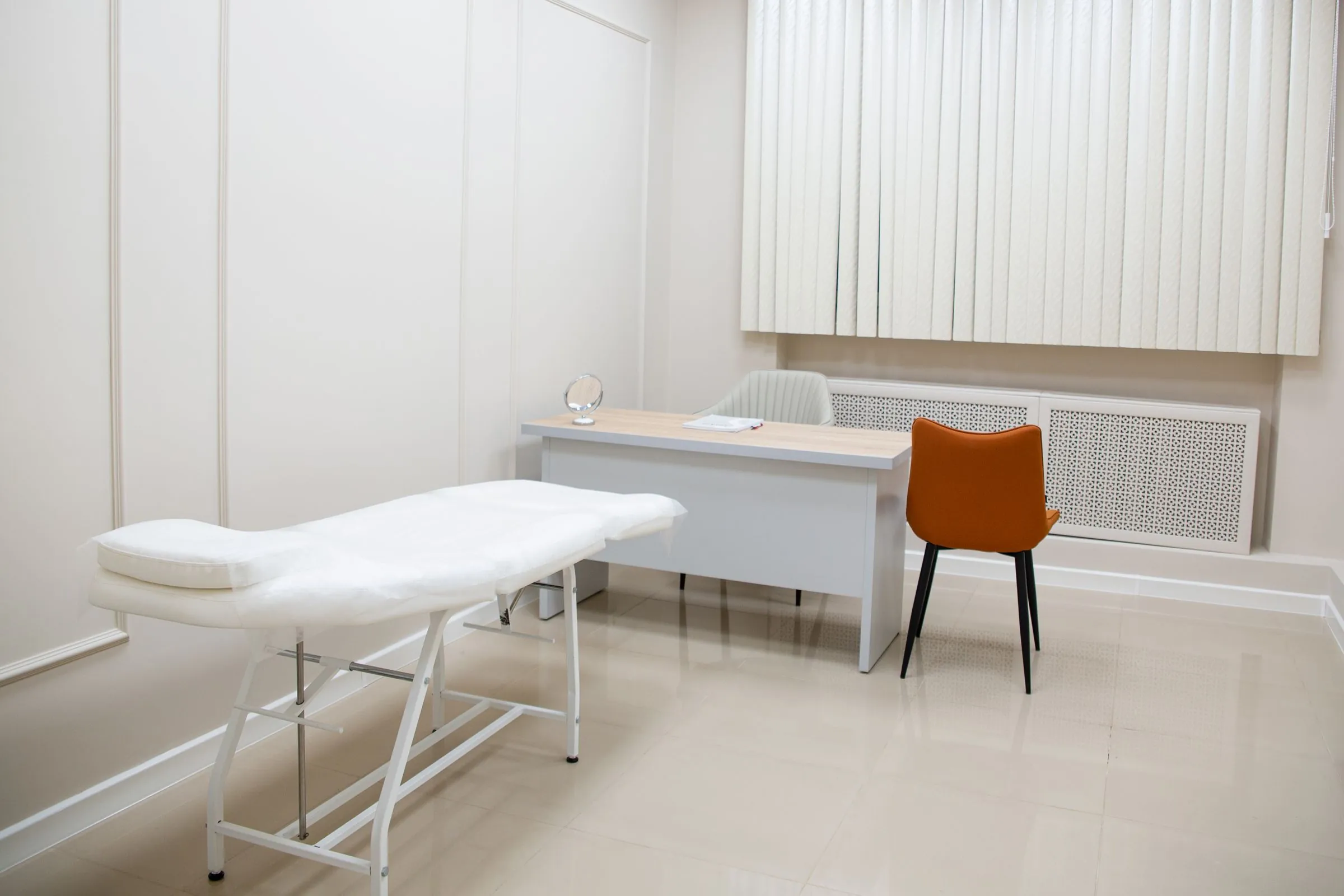 A calm, uncluttered consulting room with a desk and chairs