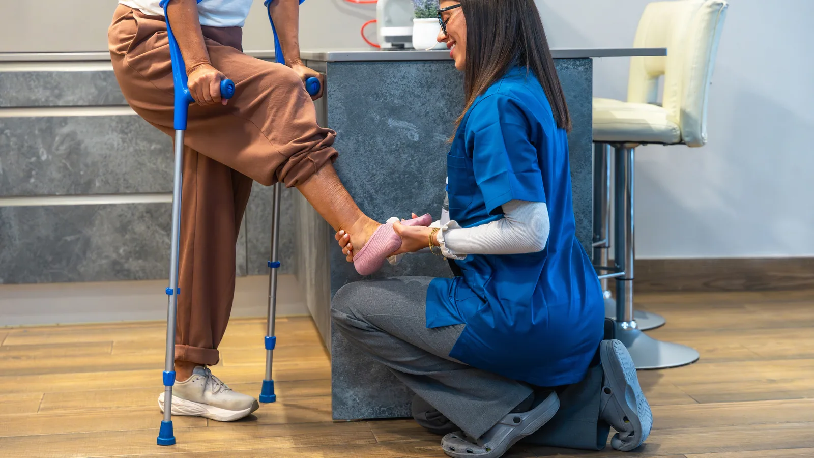 A doctor at a walk-in clinic in Somerset West assessing a patient's ankle injury after a sports-related accident